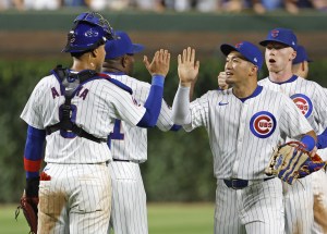 ブルワーズに勝利し、チームメートとタッチを交わすカブス・鈴木（右手前）＝シカゴ（共同） 