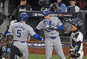 ヤンキース戦の１回、フリーマン（５）の先制２ランで生還し、迎えるドジャース・大谷＝ニューヨーク（共同）