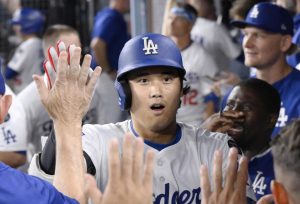 米大リーグ、フィリーズ戦の８回、５０号ソロを放ち、祝福されるドジャース・大谷翔平。メジャー史上６人目となる２年連続のシーズン５０本塁打に到達した＝１６日、ロサンゼルス（共同）