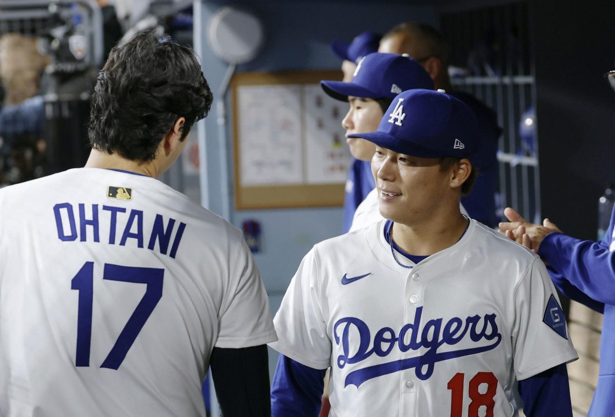 レッズ戦の７回途中、２失点で降板しベンチで大谷（１７）と言葉を交わすドジャース・山本＝ロサンゼルス（共同）