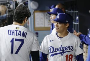 レッズ戦の７回途中、２失点で降板しベンチで大谷（１７）と言葉を交わすドジャース・山本＝ロサンゼルス（共同）