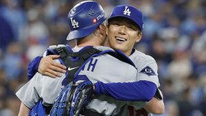 米大リーグ、ブルージェイズとのワールドシリーズ第２戦で完投勝利を挙げ、捕手スミスと抱き合うドジャースの山本由伸＝２５日、トロント（共同）
