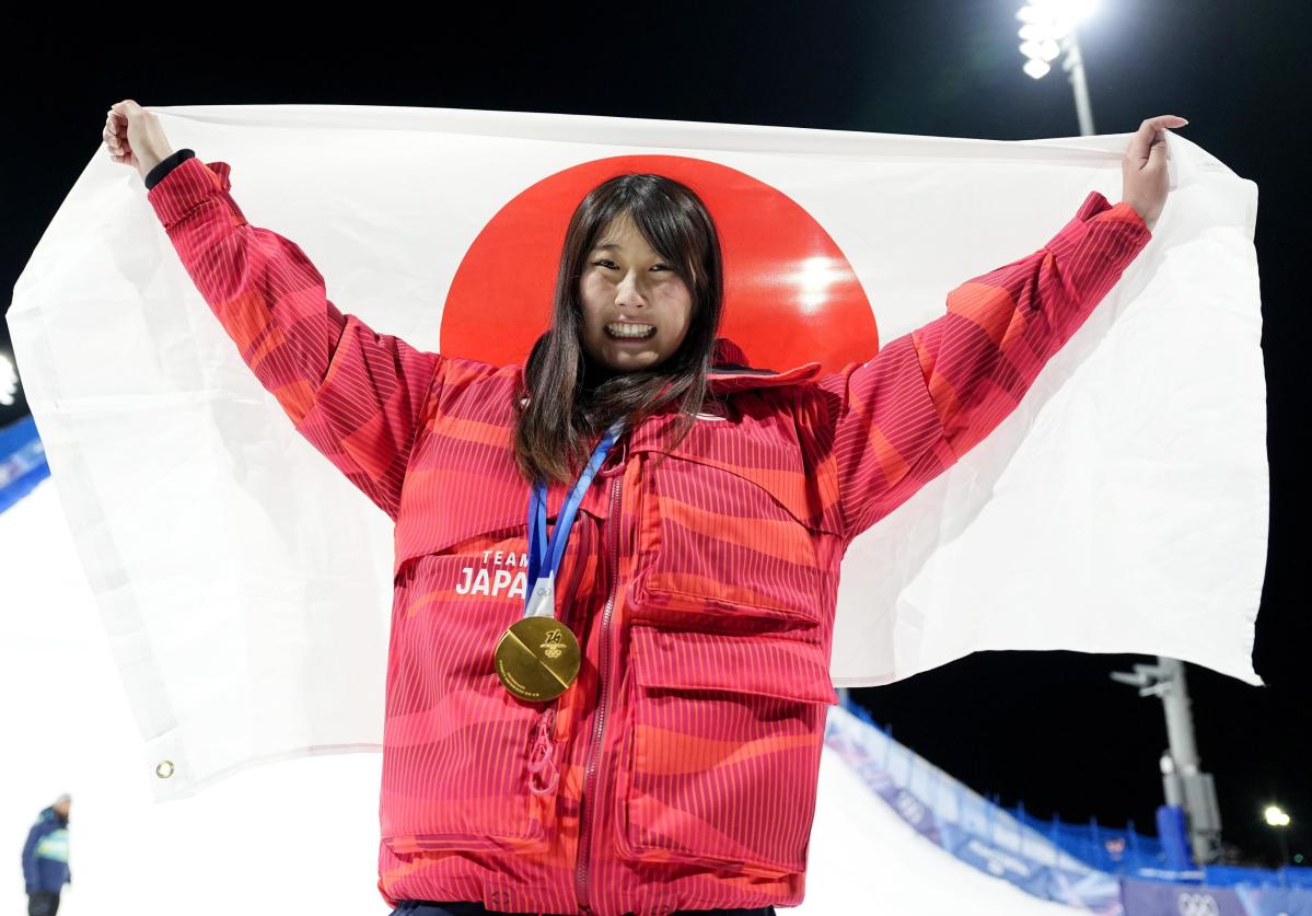 ミラノ・コルティナ冬季五輪のスノーボード女子ビッグエアで金メダルを獲得し、日の丸を掲げる村瀬心椛＝９日、イタリア・リビーニョ（共同）