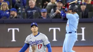 ブルージェイズ戦の１回、岡本（右奥）と対戦するドジャース・大谷。空振り三振に仕留めた＝トロント（共同）