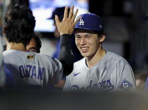 メッツ戦の７回を投げ終えてベンチで大谷（左）とタッチを交わすドジャース・佐々木＝ニューヨーク（共同）