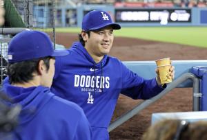 佐々木朗と話す大谷 米大リーグ・大谷 　カージナルス戦で先発を外れ、ベンチで佐々木朗（手前）と言葉を交わすドジャース・大谷＝ロサンゼルス（共同）